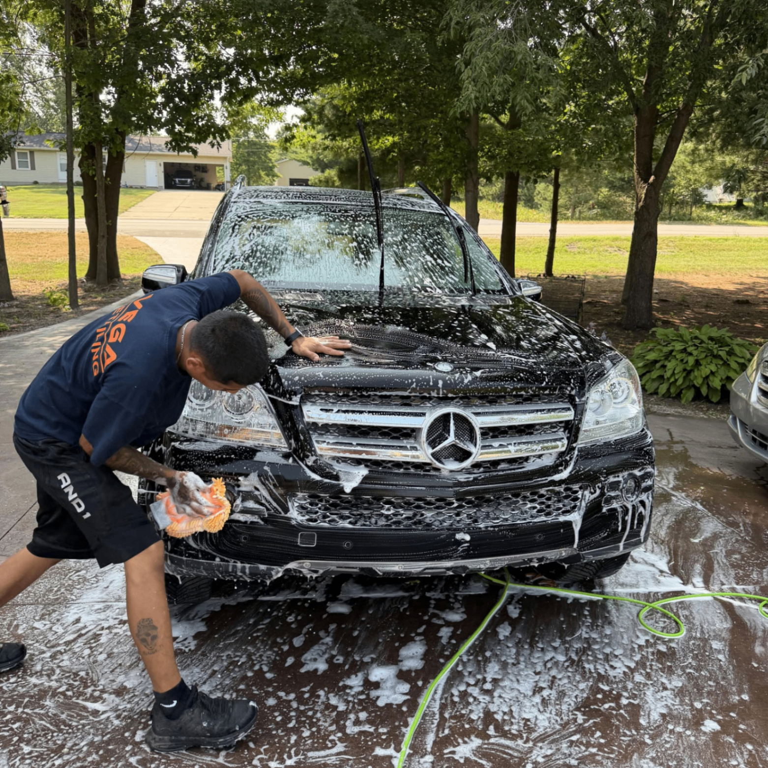 Vega Detailing crew foam washing a black Mercedes SUV